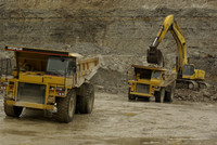 Excavator loading haul trucks.